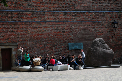 841178 Afbeelding van een groepje jongeren bij de Runensteen op het Domplein te Utrecht.